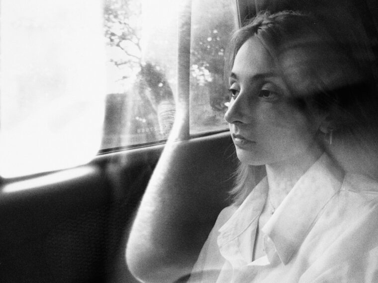 Mujer respirando junto a una ventana para calmar la ansiedad
