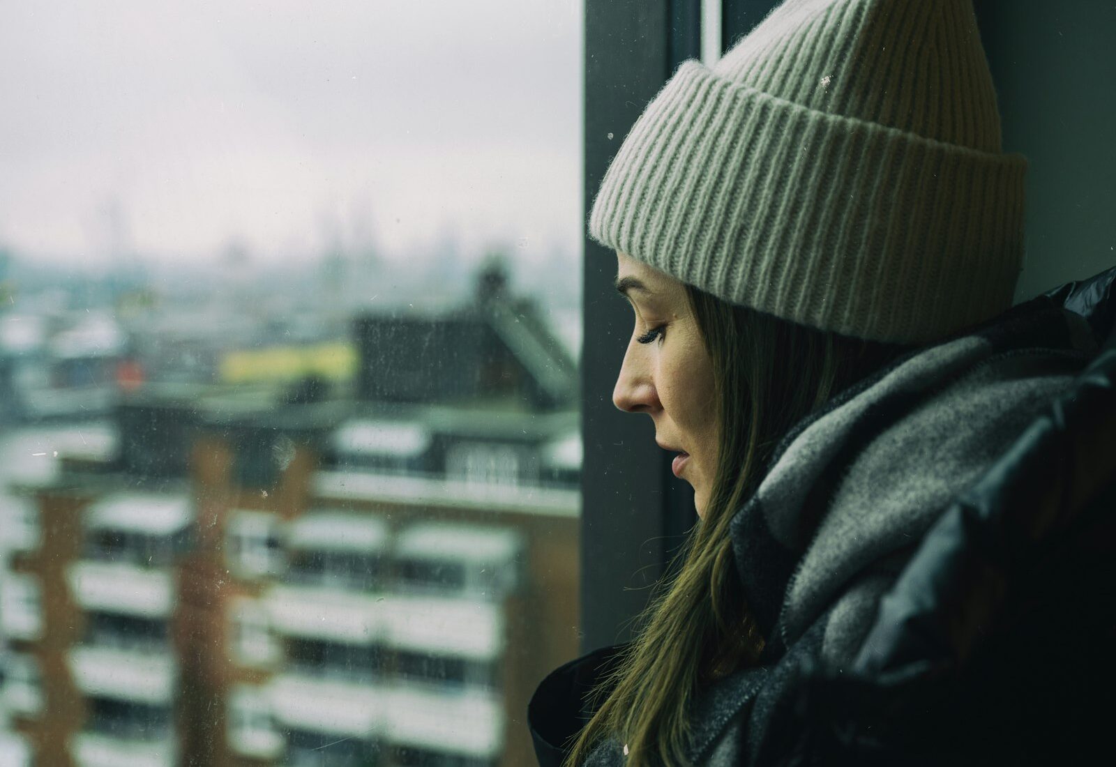 Mujer pensativa junto a una ventana: terapia para la ansiedad en León