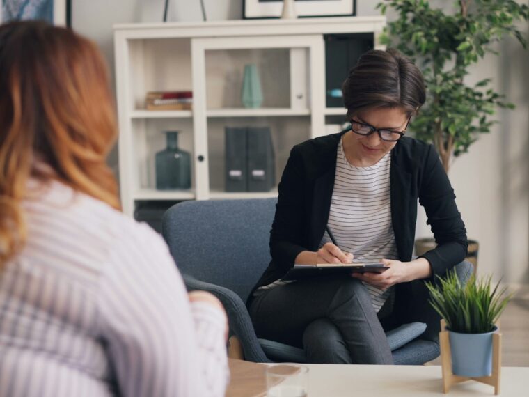 Psicóloga con un cuaderno durante una primera consulta