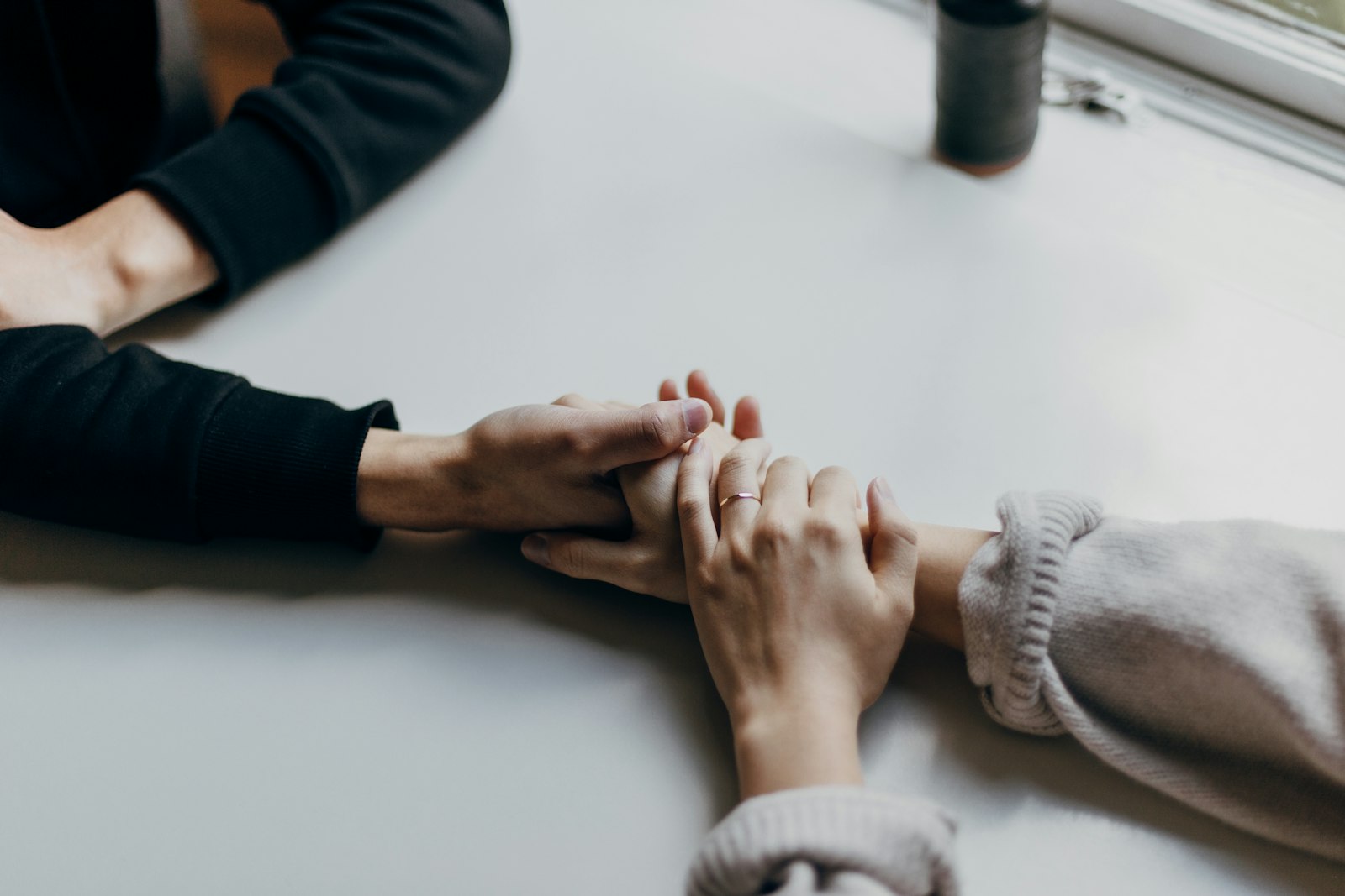 Dos manos unidas sobre una mesa: terapia sexual y de pareja en León