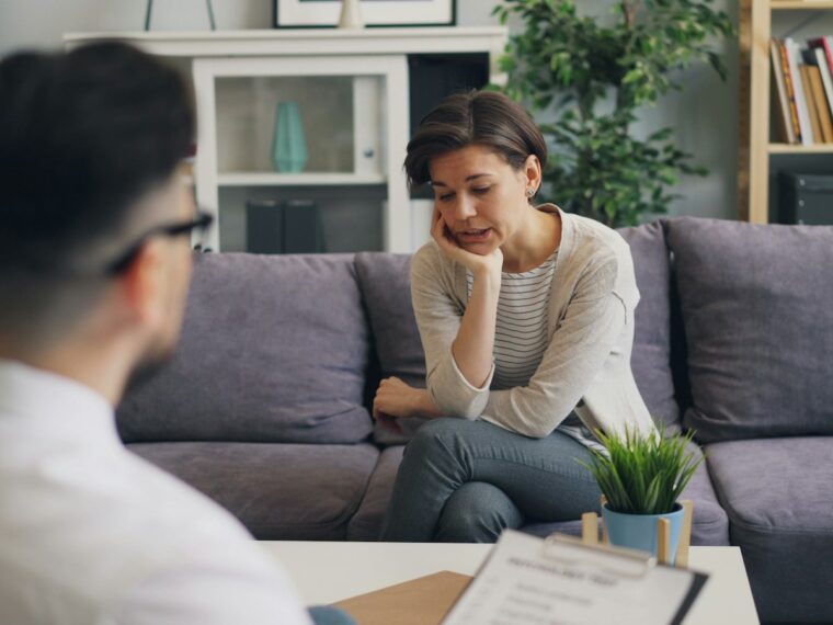 Pareja hablando en un sofá sobre una infidelidad