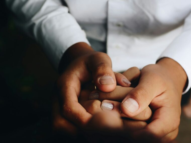 Dos personas cogidas de la mano tras una ruptura de pareja
