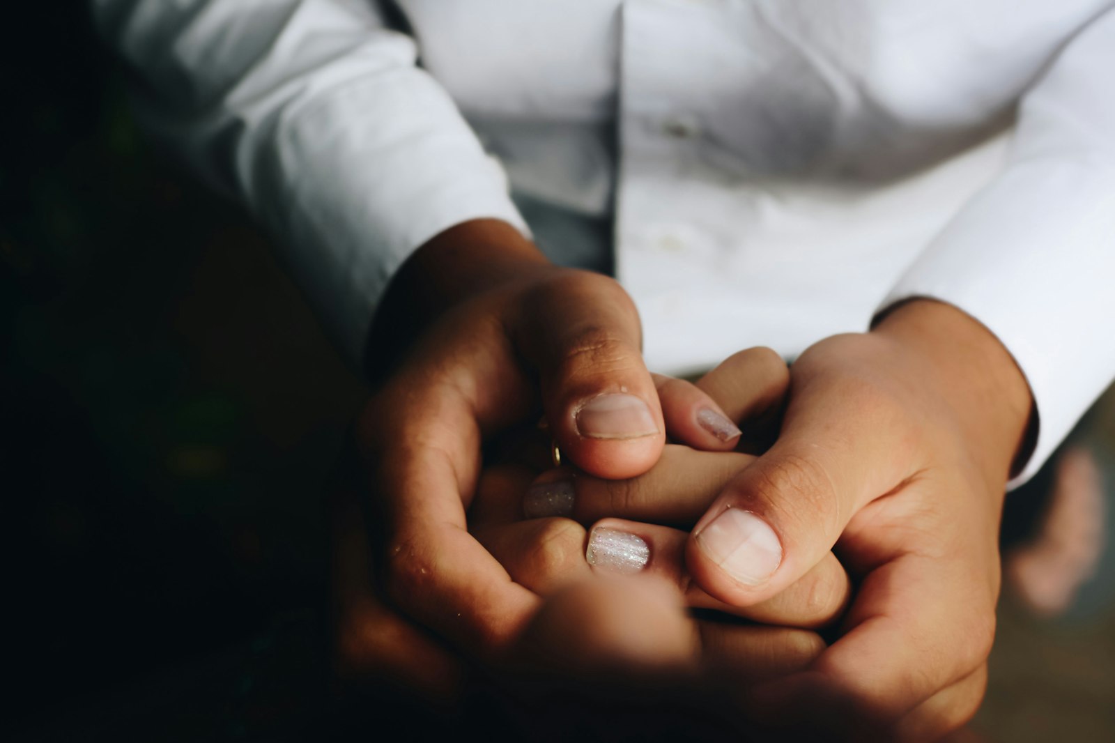 Dos personas cogidas de la mano tras una ruptura de pareja